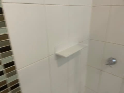Ceramic shelf installed in a tiled shower