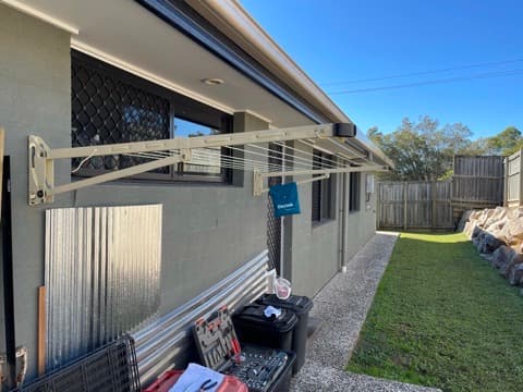 Wall-mounted clothesline over a side path